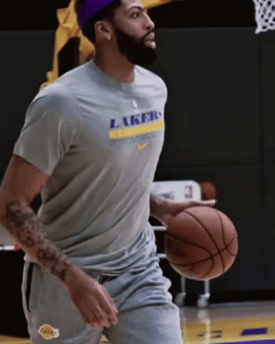 A Man Wearing A Lakers T-Shirt Holds A Basketball GIF