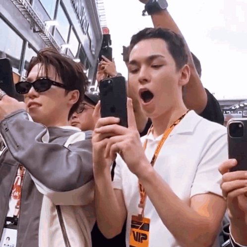 A Man Wearing A Lanyard With The Word Vip On It Looks At His Phone GIF