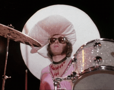 A Man Wearing A Large White Hat And Sunglasses Playing Drums GIF
