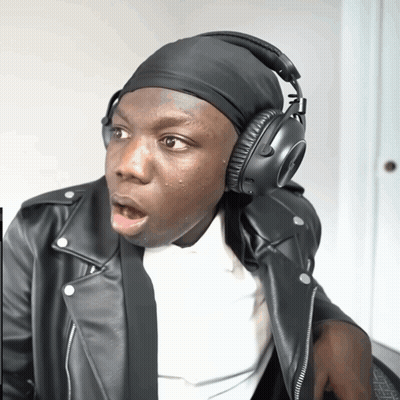 A Man Wearing A Leather Jacket And Headphones Looks Surprised GIF
