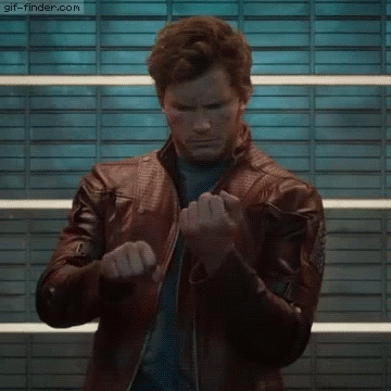 A Man Wearing A Leather Jacket Is Standing In Front Of A Wall . GIF