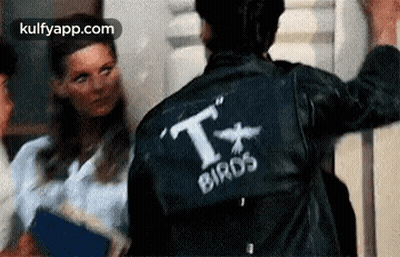 A Man Wearing A Leather Jacket With The Word Birds On It . GIF