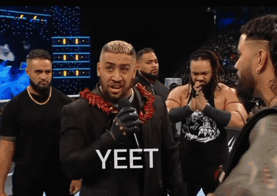 A Man Wearing A Lei Stands In Front Of A Microphone GIF