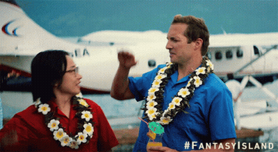 A Man Wearing A Lei Stands Next To A Woman Wearing A Lei And A Plane In The Background GIF
