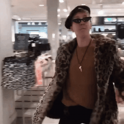 A Man Wearing A Leopard Print Coat And Sunglasses GIF