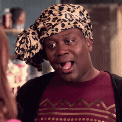 A Man Wearing A Leopard Print Head Scarf And A Maroon Shirt GIF
