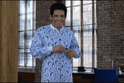 A Man Wearing A Leopard Print Pajama Top Is Standing In Front Of A Window GIF