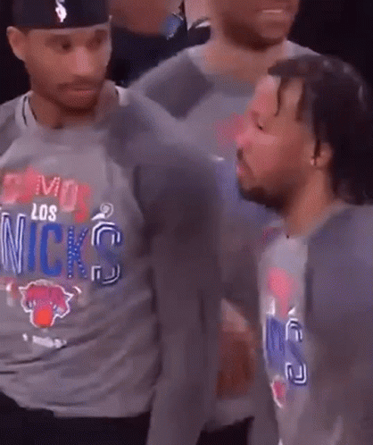 A Man Wearing A Los Angeles Knicks Shirt Is Talking To Another Man . GIF