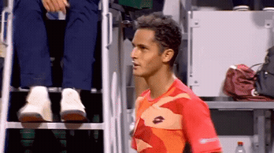 A Man Wearing A Lotto Shirt Stands In Front Of A Referee 'S Chair GIF