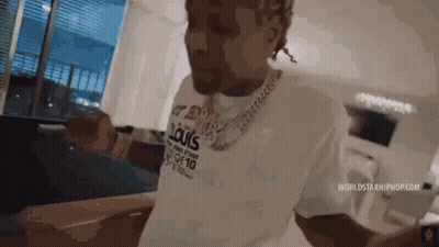 A Man Wearing A Louis Vuitton Shirt Is Standing In A Room . GIF
