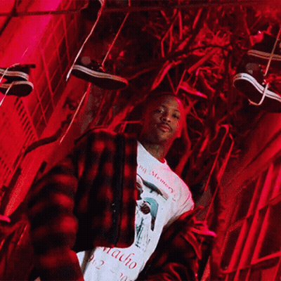 A Man Wearing A Macho Shirt Stands In Front Of A Red Light GIF