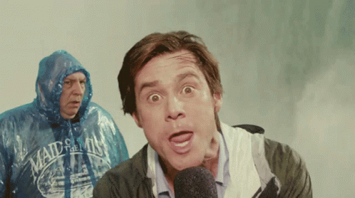 A Man Wearing A Maid Of The Mist Shirt Stands Behind A Man Wearing A Plastic Raincoat GIF