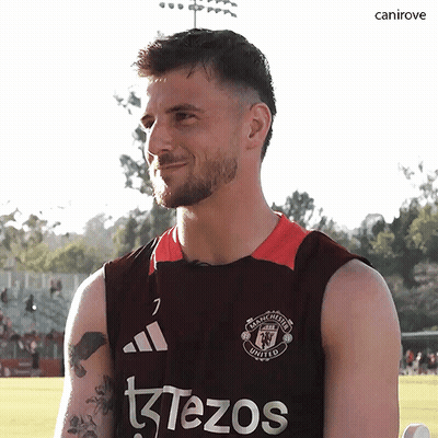 a man wearing a manchester united jersey looks at the camera