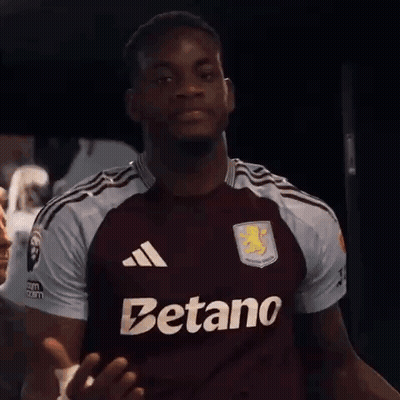 A Man Wearing A Maroon Jersey That Says Betano On The Front GIF