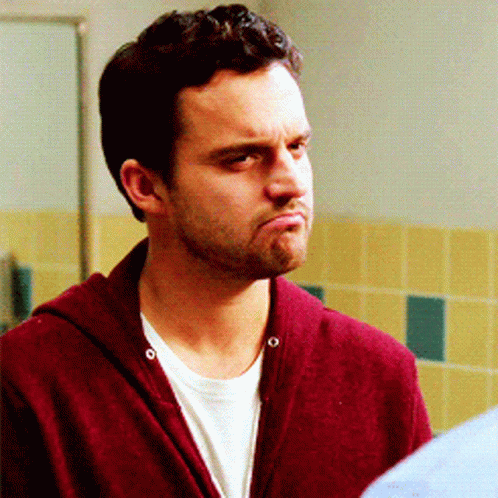 A Man Wearing A Maroon Sweater And A White Shirt Makes A Funny Face GIF