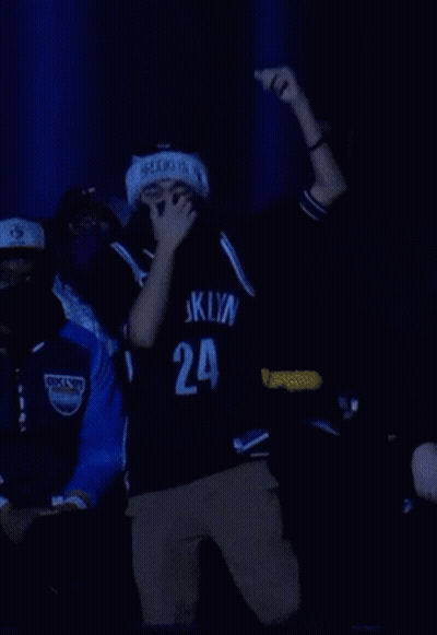 A Man Wearing A Mask And A Brooklyn Jersey Is Dancing GIF