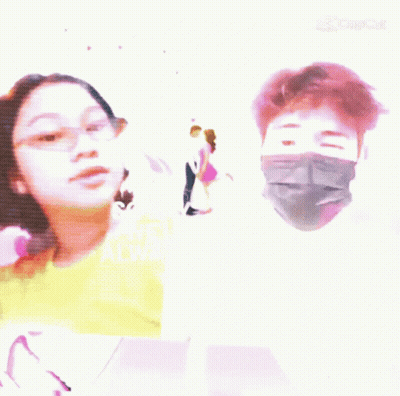 a man wearing a mask and a girl wearing glasses are standing next to each other .