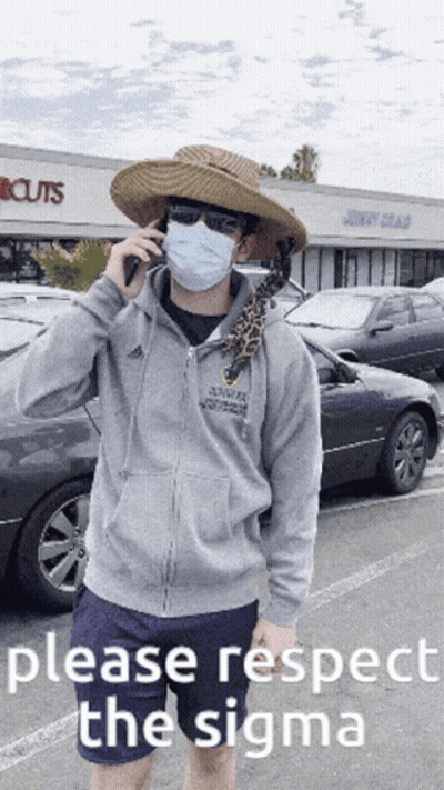 A Man Wearing A Mask And A Hat Is Talking On A Cell Phone In Front Of A Store That Says Cuts GIF
