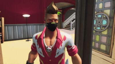 A Man Wearing A Mask And A Necklace Stands In A Room GIF