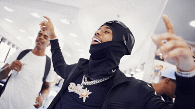 A Man Wearing A Mask And A Necklace With A Pendant That Says ' Snoop Dogg ' On It GIF