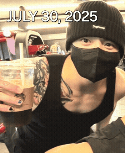 A Man Wearing A Mask And A Supreme Beanie Is Holding A Cup Of Coffee On July 30 2025 GIF