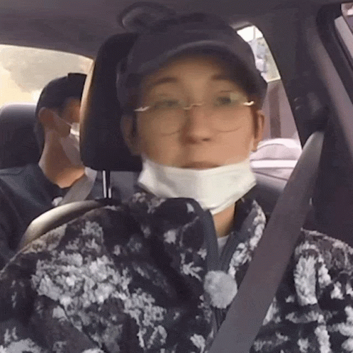 A Man Wearing A Mask And Glasses Is Sitting In A Car GIF