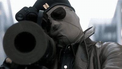 A Man Wearing A Mask And Sunglasses Is Aiming A Gun GIF