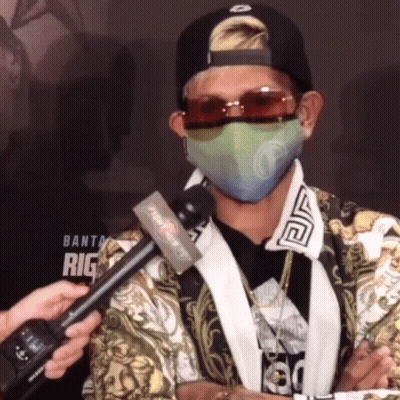 A Man Wearing A Mask And Sunglasses Is Being Interviewed By A Reporter From Fight Night Tv GIF
