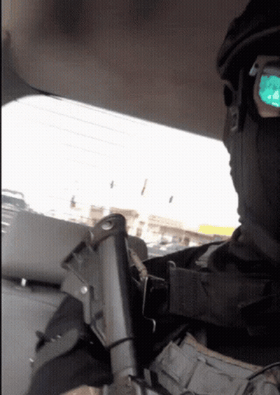 A Man Wearing A Mask And Sunglasses Is Holding A Gun In His Hand GIF