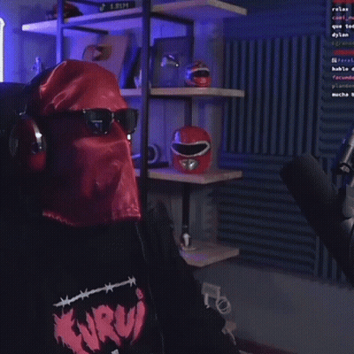 A Man Wearing A Mask And Sunglasses Is Holding A Microphone In A Room . GIF