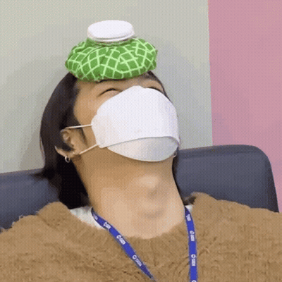 A Man Wearing A Mask Has An Ice Pack On Top Of His Head GIF