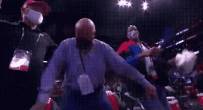 A Man Wearing A Mask Is Dancing In A Boxing Ring . GIF