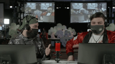 A Man Wearing A Mask Is Giving A Thumbs Up While Sitting In Front Of A Microphone GIF