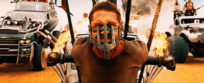 A Man Wearing A Mask Is Sitting In Front Of A Row Of Cars GIF