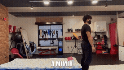 A Man Wearing A Mask Is Standing In A Gym With The Words A Mimir Behind Him GIF