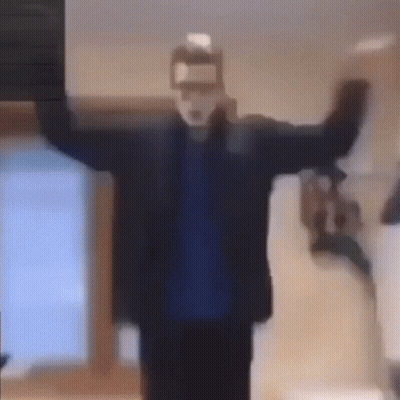 A Man Wearing A Mask Is Standing In A Room With His Arms Outstretched And A Bottle Of Milk In His Hand . GIF