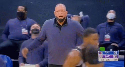 A Man Wearing A Mask Is Standing In Front Of A Basketball Player During A Basketball Game . GIF