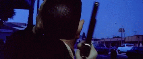 A Man Wearing A Mask Is Standing In Front Of A Building That Says ' Motel ' On It GIF