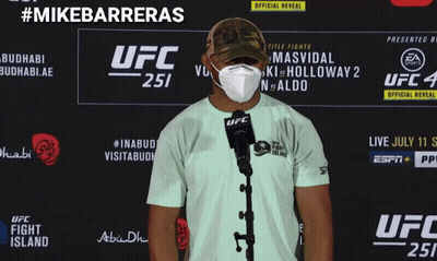 A Man Wearing A Mask Is Standing In Front Of A Ufc Sign GIF