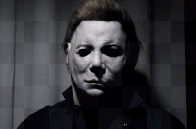 A Man Wearing A Mask Looks At The Camera GIF