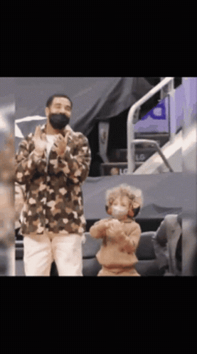 A Man Wearing A Mask Stands Next To A Young Boy Wearing A Mask GIF