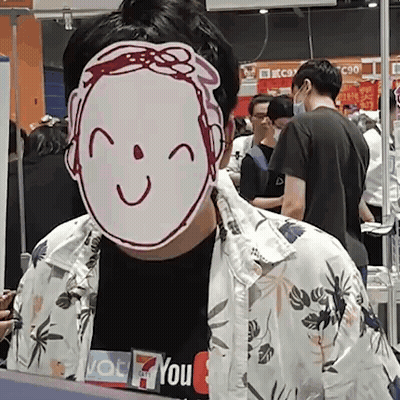 A Man Wearing A Mask With A Smile On It Is Standing In Front Of A Crowd Of People . GIF