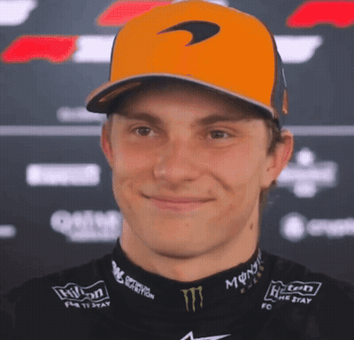 A Man Wearing A Mclaren Hat And A Monster Shirt Smiles GIF