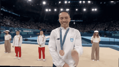 A Man Wearing A Medal Around His Neck With The Number 46 On It GIF
