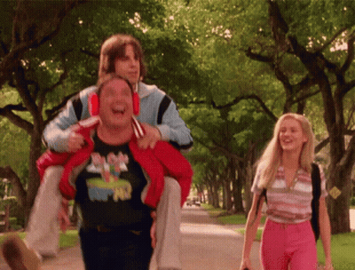 A Man Wearing A Mickey Mouse Shirt Is Carrying Another Man GIF