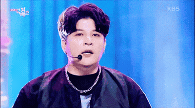 A Man Wearing A Microphone And A Necklace On A Stage With Kbs Written On The Bottom Of The Screen GIF