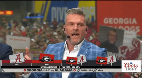 A Man Wearing A Microphone Stands In Front Of A Georgia Bulldogs Sign GIF