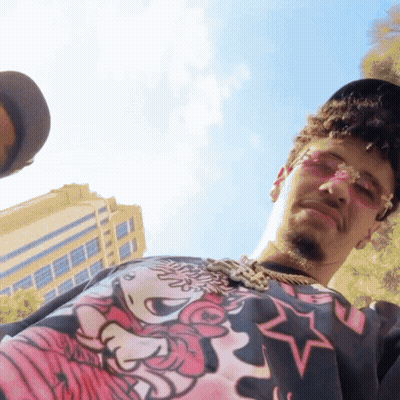 A Man Wearing A Minnie Mouse Shirt And Sunglasses Looks Down GIF