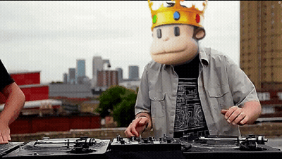 A Man Wearing A Monkey Mask And A Crown Plays Music GIF
