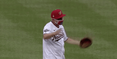 A Man Wearing A Nationals Jersey And A Mask GIF